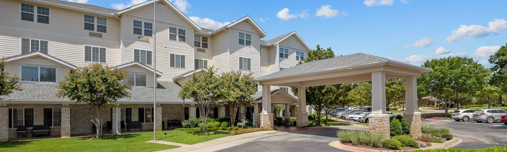 The drive in front covered entrance of Dogwood Estates senior apartment homes in Denton, TX.